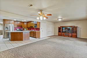 Kitchen featuring light countertops, appliances with stainless steel finishes, light colored carpet, open floor plan, and recessed lighting