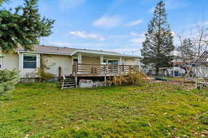 Back of house with a yard and a wooden deck