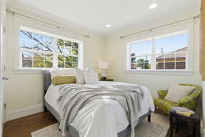 Bedroom featuring ornamental molding, dark wood-type flooring, and recessed lighting
