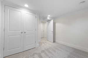 Basement featuring light colored carpet, recessed lighting, and ornamental molding