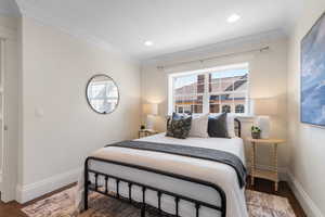Bedroom featuring crown molding, dark wood-style floors, and recessed lighting