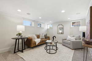 Living area with light colored carpet, crown molding, and recessed lighting