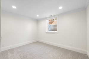 Unfurnished room with crown molding, light colored carpet, and recessed lighting