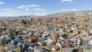 Aerial view of property and surrounding area featuring a mountainous background and nearby suburban area