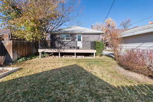Back of property featuring a wooden deck and brick siding