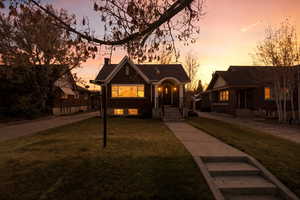 View of front facade featuring a chimney, a front yard, and concrete driveway