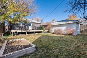 Rear view of house with a wooden deck and a garden