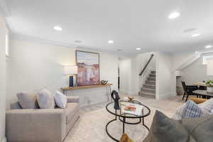 Living area featuring stairway, carpet floors, ornamental molding, and recessed lighting