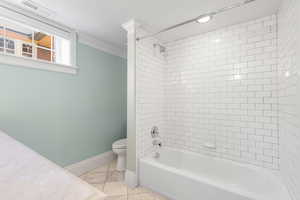 Full bathroom with shower / washtub combination, vanity, ornamental molding, and light tile patterned floors