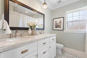 Full bathroom featuring curtained shower, double vanity, and ornamental molding