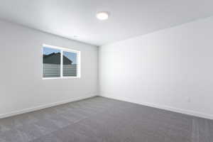 Carpeted empty room with baseboards