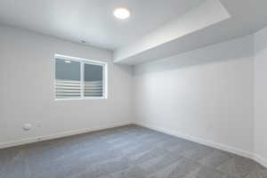 Carpeted spare room featuring baseboards