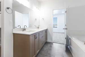 Full bathroom featuring double vanity and a bath