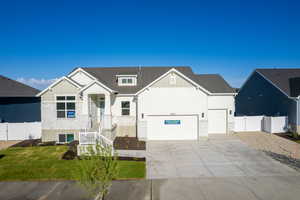 View of front of house with driveway, stone siding, and board and batten siding