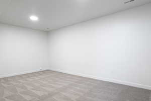 Spare room featuring carpet flooring and baseboards