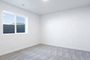 Carpeted spare room featuring baseboards