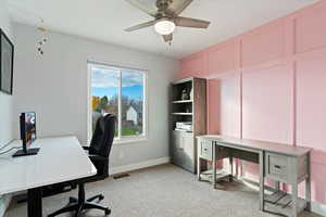 Office with light colored carpet, a decorative wall, and ceiling fan