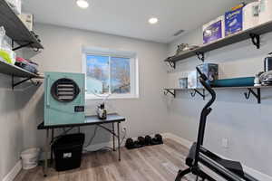 Workout room with light wood-type flooring and recessed lighting could also be utilized as a walk-in closet
