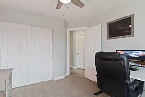 Office area with light carpet and ceiling fan
