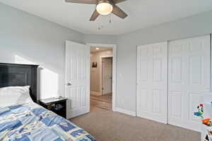Bedroom with carpet floors, a closet, and ceiling fan