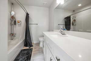 Bathroom with shower / bath combination with curtain and vanity