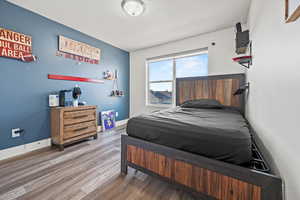 Bedroom with baseboards and wood finished floors