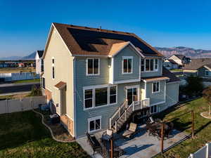 Rear view of property with a mountain view, a patio area, outdoor dining area, and a fenced backyard