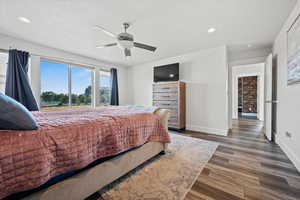 Bedroom featuring dark wood-style floors, a ceiling fan, a textured ceiling, and recessed lighting