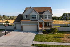 Craftsman-style home featuring driveway, roof with shingles, and a porch