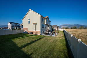 View of home's exterior featuring a mountain view, a patio, a fenced backyard, and brick siding