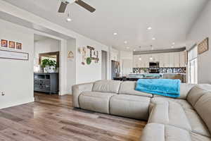 Living room with light wood-style floors, recessed lighting, and a ceiling fan