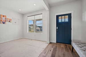 Entrance foyer with wood finished floors and recessed lighting