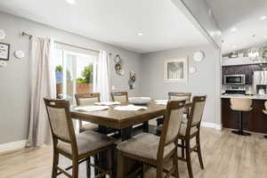 Dining space with light wood-style floors, recessed lighting, and lofted ceiling