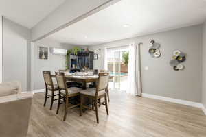Dining area with light wood-style floors, a wall mounted AC, and recessed lighting