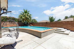 View of swimming pool featuring a patio and a fenced backyard