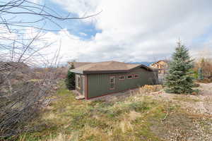 View of side of property with roof with shingles