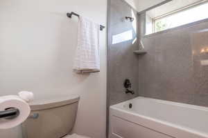 Bathroom featuring toilet and washtub / shower combination