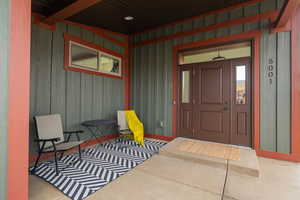 View of exterior entry featuring a porch and board and batten siding