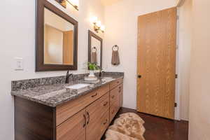 Full bath featuring double vanity and concrete floors