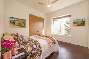 Bedroom with ceiling fan, a closet, and concrete flooring