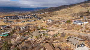 Aerial view of property and surrounding area with nearby suburban area and a mountainous background