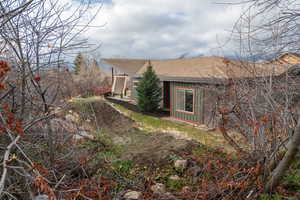 View of property exterior featuring roof with shingles and board and batten siding
