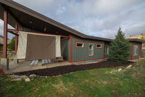 Rear view of house featuring a yard, board and batten siding, and a patio