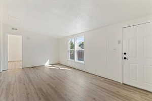 Foyer entrance with a textured ceiling and light wood finished floors