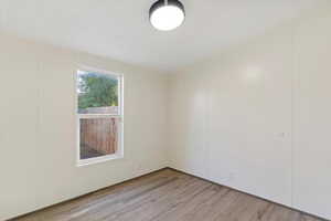 Unfurnished room featuring light wood-style flooring and a textured ceiling
