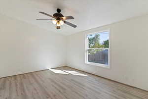 Spare room featuring a textured ceiling, light wood finished floors, and a ceiling fan