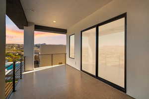 Balcony at dusk featuring a patio