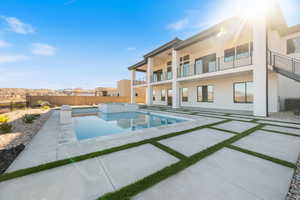 View of pool featuring a patio area, a fenced backyard, a balcony, and a pool with connected hot tub