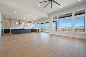 Unfurnished living room with a mountain view, light wood-type flooring, recessed lighting, and ceiling fan