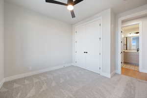 Unfurnished bedroom featuring carpet flooring, a closet, and a ceiling fan